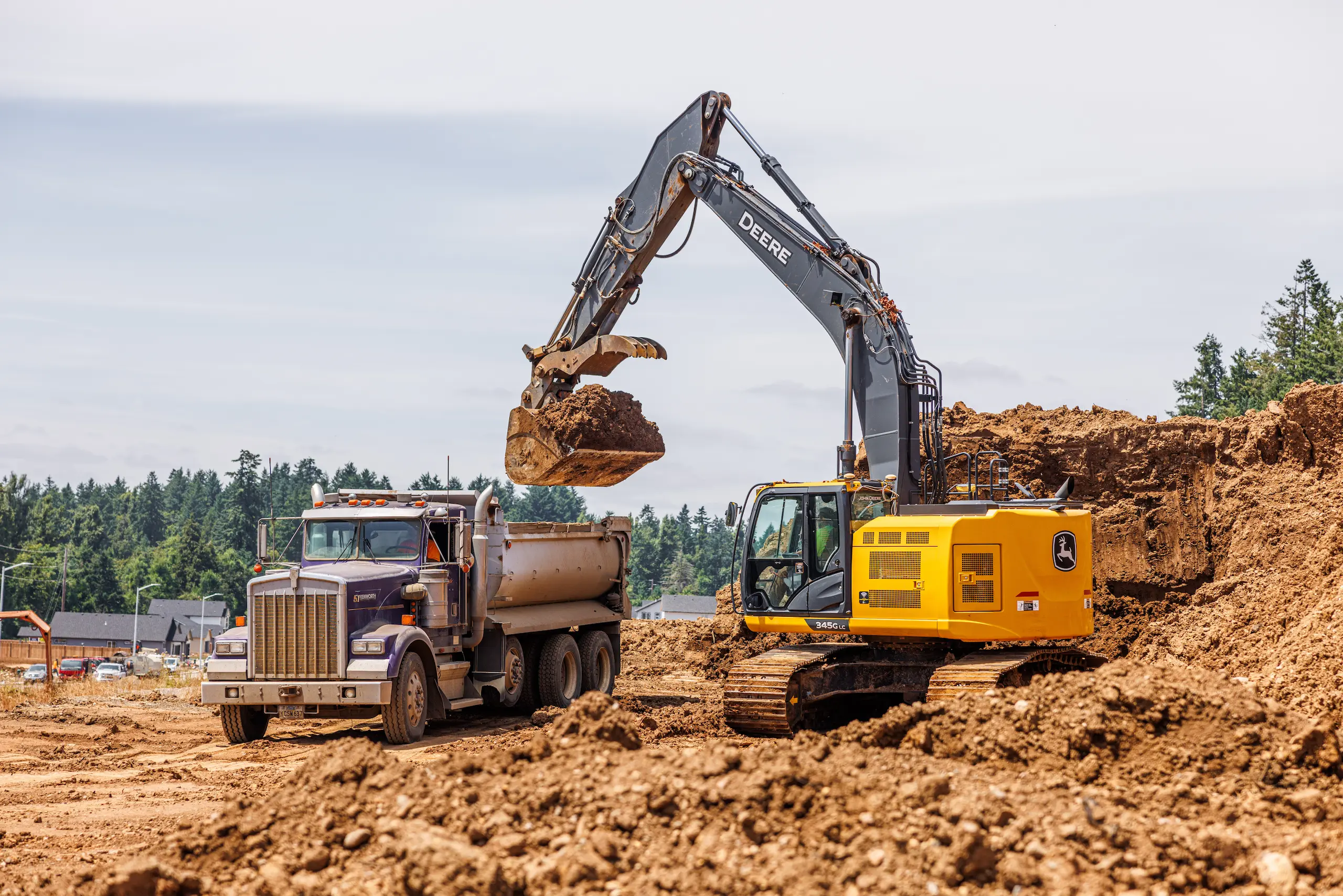 Excavator loading dirt into dump truck
